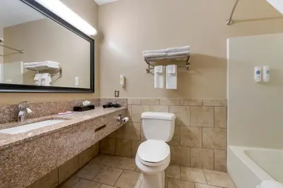 a bathroom with a toilet and a sink and a tub at Econo Lodge Shelbyville North in Shelbyville