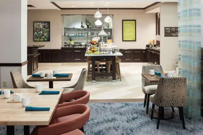 a restaurant with tables and chairs and a bar at Hilton Garden Inn Cincinnati/Mason in Mason