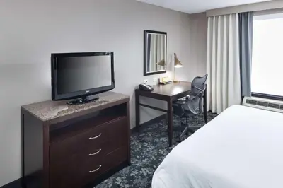 a hotel room with a bed and a tv and a desk at Hilton Garden Inn Cincinnati/Mason in Mason