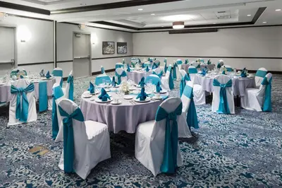 a banquet hall with tables with blue and white table settings at Hilton Garden Inn Cincinnati/Mason in Mason