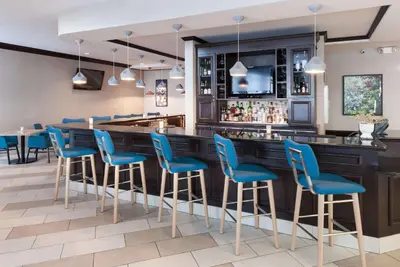 a bar with blue bar stools in a restaurant at Hilton Garden Inn Cincinnati/Mason in Mason