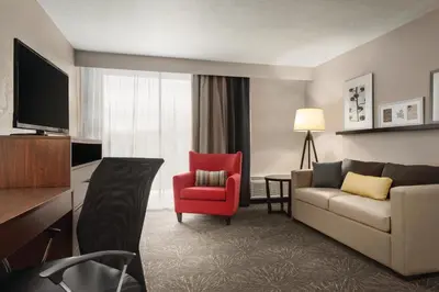 a living room with a couch and a red chair at Country Inn & Suites by Radisson, Erlanger - Cincinnati South in Erlanger