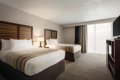 a hotel room with two beds and a television at Country Inn & Suites by Radisson, Erlanger - Cincinnati South in Erlanger