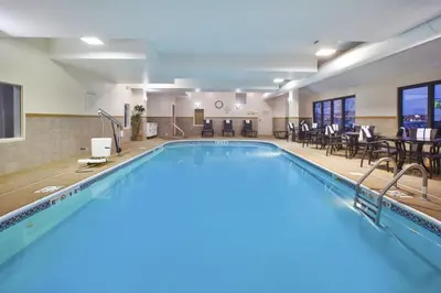 a pool with chairs and tables in a hotel room at Holiday Inn Express Tiffin by IHG in Tiffin