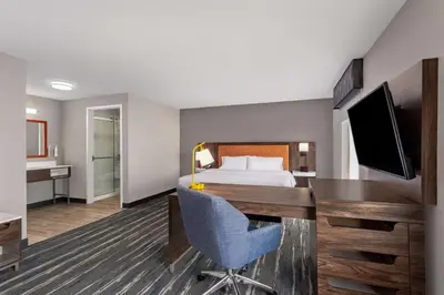 a hotel room with a desk and a bed at Hampton Inn & Suites Richmond in Richmond