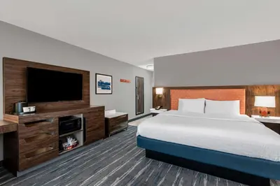 a hotel room with a bed and a flat screen tv at Hampton Inn & Suites Richmond in Richmond