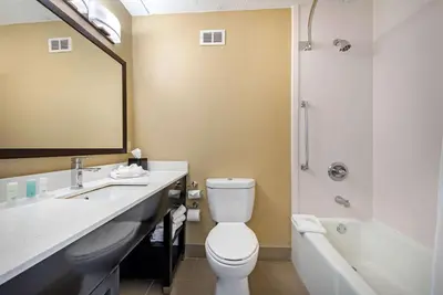 a bathroom with a toilet and a sink and a tub at Clarion Hotel Conference Center Lexington North in Lexington