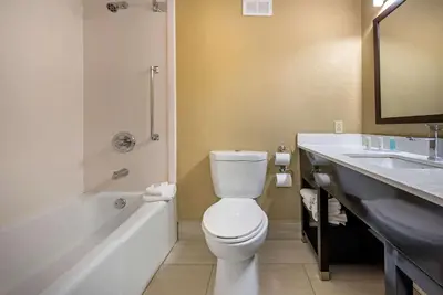 a bathroom with a toilet and a tub and a sink at Clarion Hotel Conference Center Lexington North in Lexington