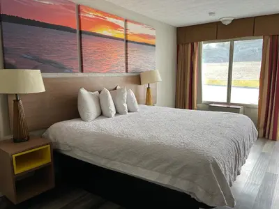 a hotel room with a bed and two windows at Days Inn & Suites by Wyndham Dayton North in Dayton