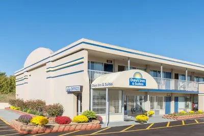 a hotel building with flowers in front of it at Days Inn & Suites by Wyndham Dayton North in Dayton