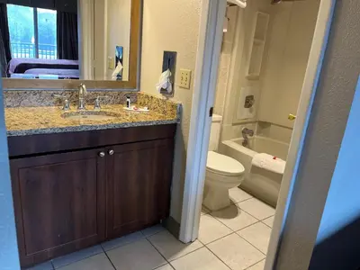a bathroom with a sink and a toilet and a mirror at Days Inn & Suites by Wyndham Dayton North in Dayton