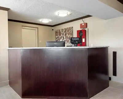 a large wooden reception desk with a laptop on top at Red Roof Inn Dayton Huber Heights in Dayton