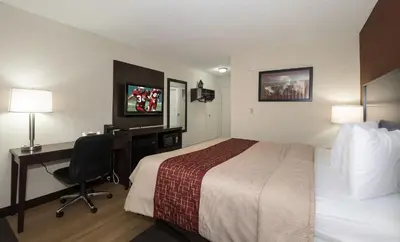 a hotel room with a bed and a desk with a computer at Red Roof Inn Dayton Huber Heights in Dayton