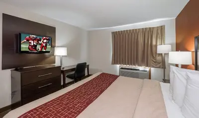 a hotel room with a bed and a desk at Red Roof Inn Dayton Huber Heights in Dayton