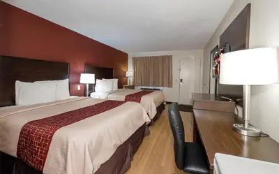 a hotel room with two beds and a table with a lamp at Red Roof Inn Dayton Huber Heights in Dayton