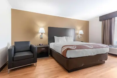a hotel room with a bed and a chair at Quality Inn Fairborn near Wright Patterson AFB in Fairborn