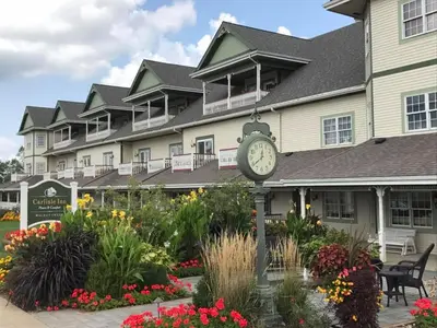 a clock in front of a large building with flowers at Carlisle Inn Walnut Creek in Walnut Creek