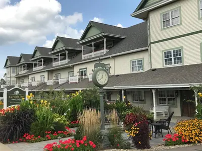 a clock in front of a large building with flowers at Carlisle Inn Walnut Creek in Walnut Creek