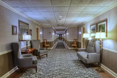 a hallway with chairs and tables in a building at Carlisle Inn Walnut Creek in Walnut Creek