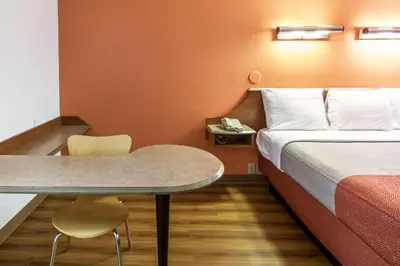 a hotel room with a bed and a table at Motel 6-Dayton, OH - Englewood in Englewood