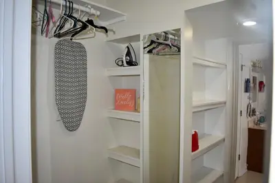 a walk in closet with white shelves and shoes at Cozy 2nd story Flat near downtown in Adrian
