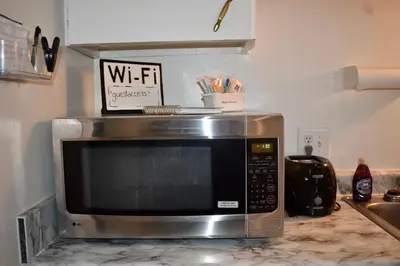 a microwave sitting on a counter in a kitchen at Cozy 2nd story Flat near downtown in Adrian