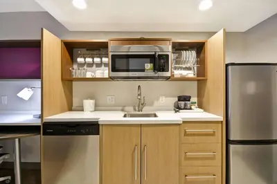 a kitchen with a sink and a microwave at Home2 Suites By Hilton Columbus Airport East Broad in Columbus