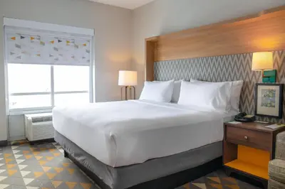 a large white bed in a hotel room at Holiday Inn Toledo - Maumee I-80/90 by IHG in Maumee
