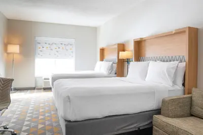 a hotel room with two beds and a couch at Holiday Inn Toledo - Maumee I-80/90 by IHG in Maumee