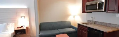a living room with a couch in a hotel room at Holiday Inn Express Toledo-Oregon by IHG in Oregon
