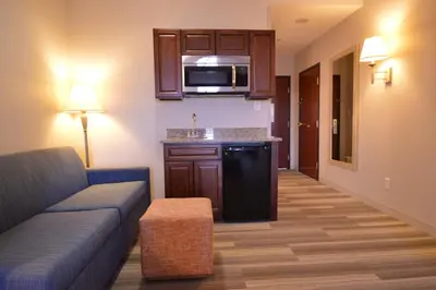 a living room with a couch and a kitchen at Holiday Inn Express Toledo-Oregon by IHG in Oregon