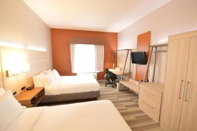 a hotel room with two beds and a desk at Holiday Inn Express Toledo-Oregon by IHG in Oregon
