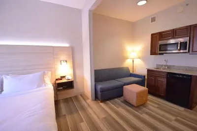 a hotel room with a bed and a chair at Holiday Inn Express Toledo-Oregon by IHG in Oregon