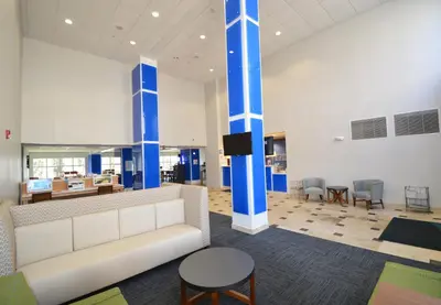 a lobby with a couch and a table and chairs at Holiday Inn Express Toledo-Oregon by IHG in Oregon
