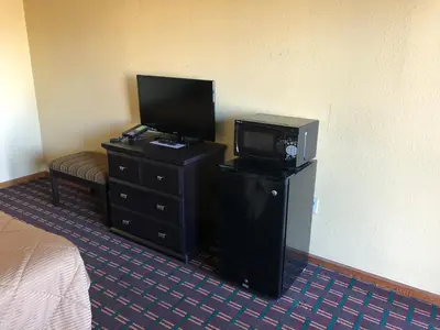 a bedroom with a tv and a dresser with a tvictericterictericter at Americas Best Value Inn Maumee/Toledo in Maumee