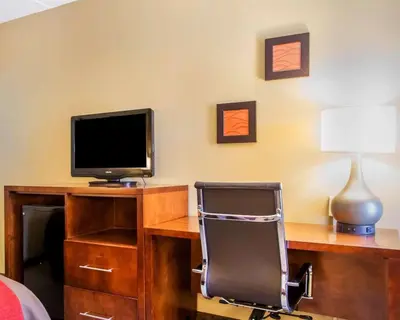 a computer desk with a chair and a television at Comfort Inn Dayton - Huber Heights in Huber Heights