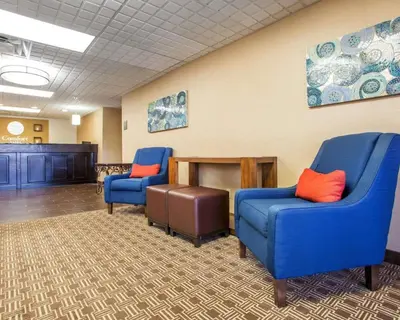 a waiting room with two blue chairs and a table at Comfort Inn Dayton - Huber Heights in Huber Heights