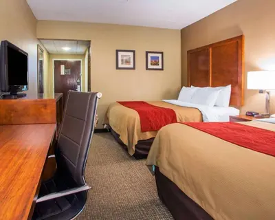 a hotel room with two beds and a desk at Comfort Inn Dayton - Huber Heights in Huber Heights