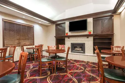 a restaurant with tables and chairs and a fireplace at Hawthorn Extended Stay by Wyndham Dayton in Dayton