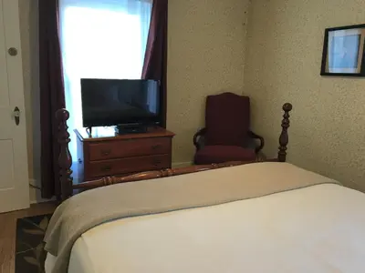 a bedroom with a bed and a tv and a chair at The Doctor's Inn in Oxford