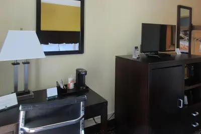 a hotel room with a desk with a tv and a lamp at Quality Inn & Suites in Cincinnati