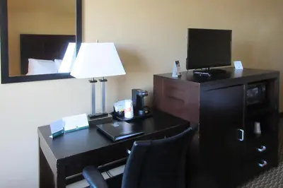 a hotel room with a desk with a lamp and a television at Quality Inn & Suites in Cincinnati