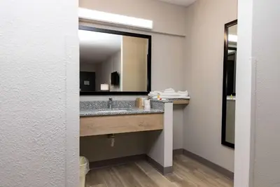 a bathroom with a sink and a large mirror at Days Inn by Wyndham Cincinnati East in Cherry Grove