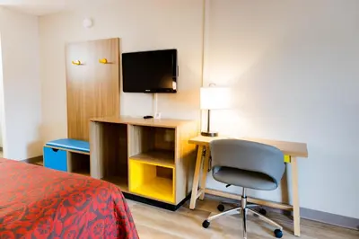 a room with a desk and a chair and a television at Days Inn by Wyndham Cincinnati East in Cherry Grove