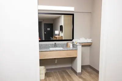 a bathroom with a sink and a large mirror at Days Inn by Wyndham Cincinnati East in Cherry Grove