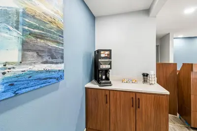 a coffee machine on a counter next to a painting at HomeTowne Studios by Red Roof Florence, KY-Cincinnati Airport in Florence