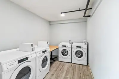a laundry room with two washing machines and a table at HomeTowne Studios by Red Roof Florence, KY-Cincinnati Airport in Florence