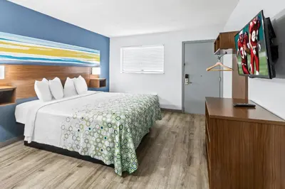 a hotel room with a bed and a flat screen tv at HomeTowne Studios by Red Roof Florence, KY-Cincinnati Airport in Florence