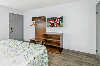 a bedroom with a bed and a dresser and a desk at HomeTowne Studios by Red Roof Florence, KY-Cincinnati Airport in Florence