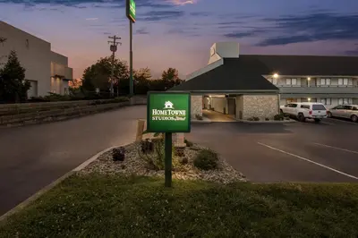 a sign in the grass in front of a parking lot at HomeTowne Studios by Red Roof Florence, KY-Cincinnati Airport in Florence